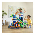 Hot Wheels City Ultimate T-Rex Garage Playset with 2 die-cast cars in use